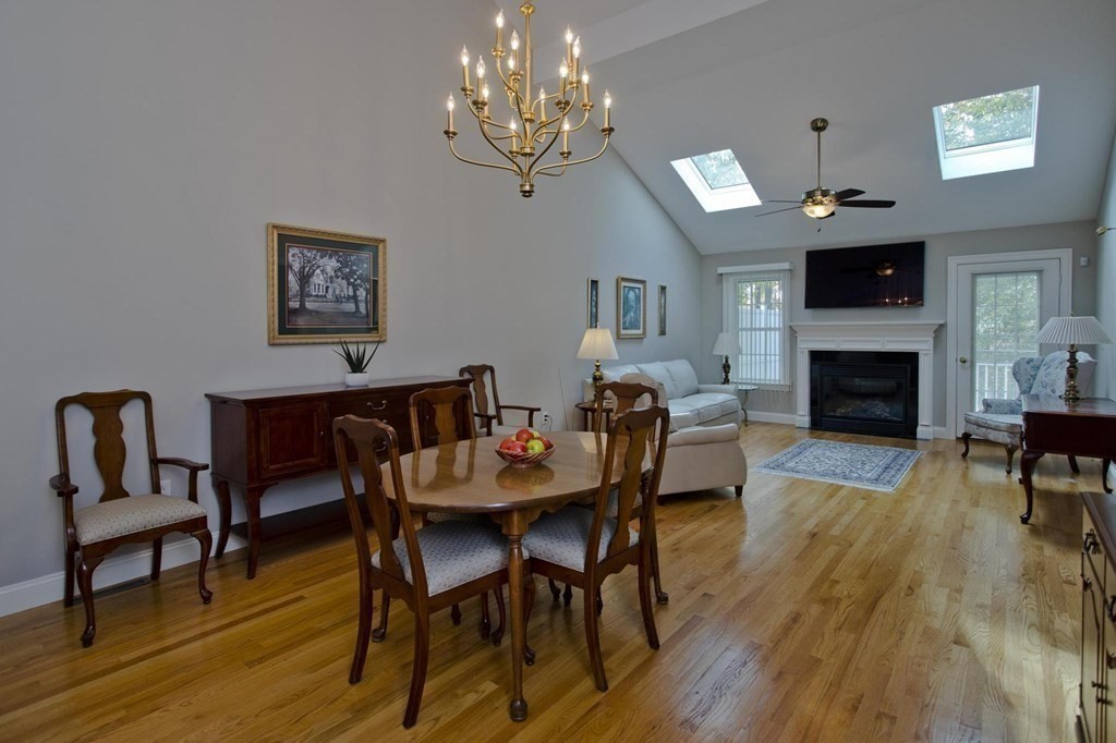 73 Beech Hill Road, Unit 73 West Springfield, MA 01089 - Photo 8 of 29 a view of a dining room with furniture a fireplace wooden floor and chandelier