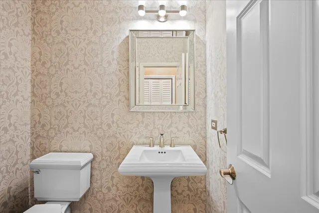 a bathroom with a toilet a sink and mirror