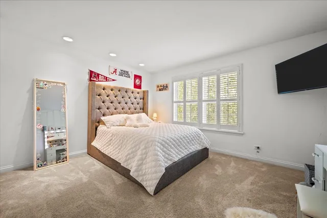 a spacious bedroom with a bed and a flat screen tv
