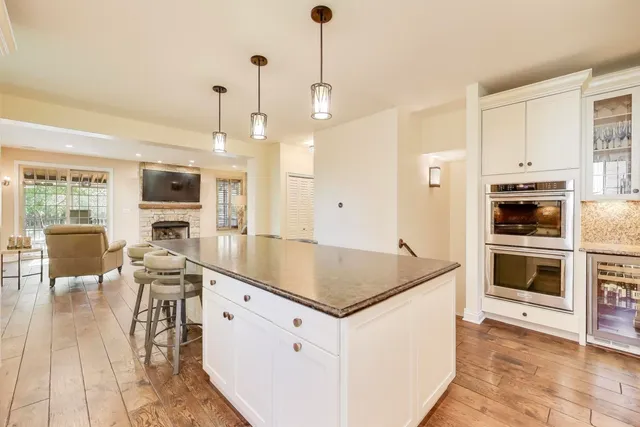 a kitchen with stainless steel appliances granite countertop a stove oven and a refrigerator with white cabinets