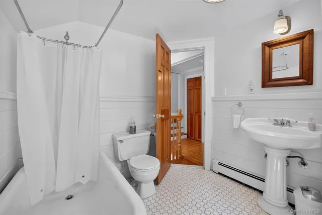 a bathroom with a sink a toilet and shower curtain