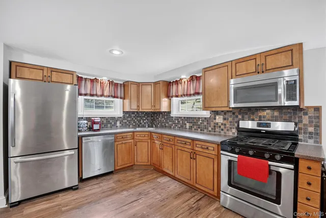 a kitchen with stainless steel appliances granite countertop a refrigerator stove top oven and sink