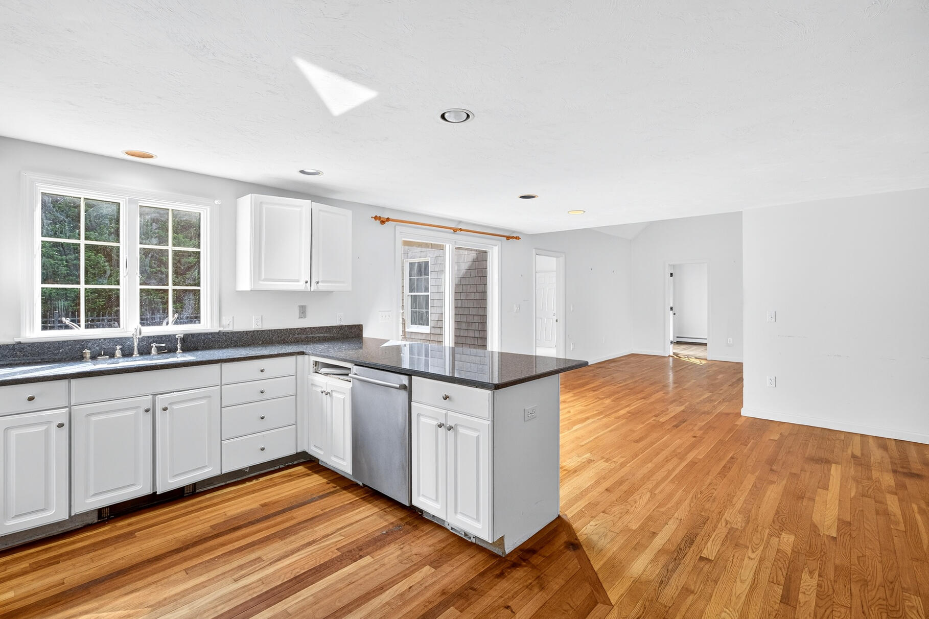 30 Fox Crossing Road Brewster, MA 02631 - Photo 14 of 36 a large kitchen with granite countertop a stove and white cabinets with wooden floor