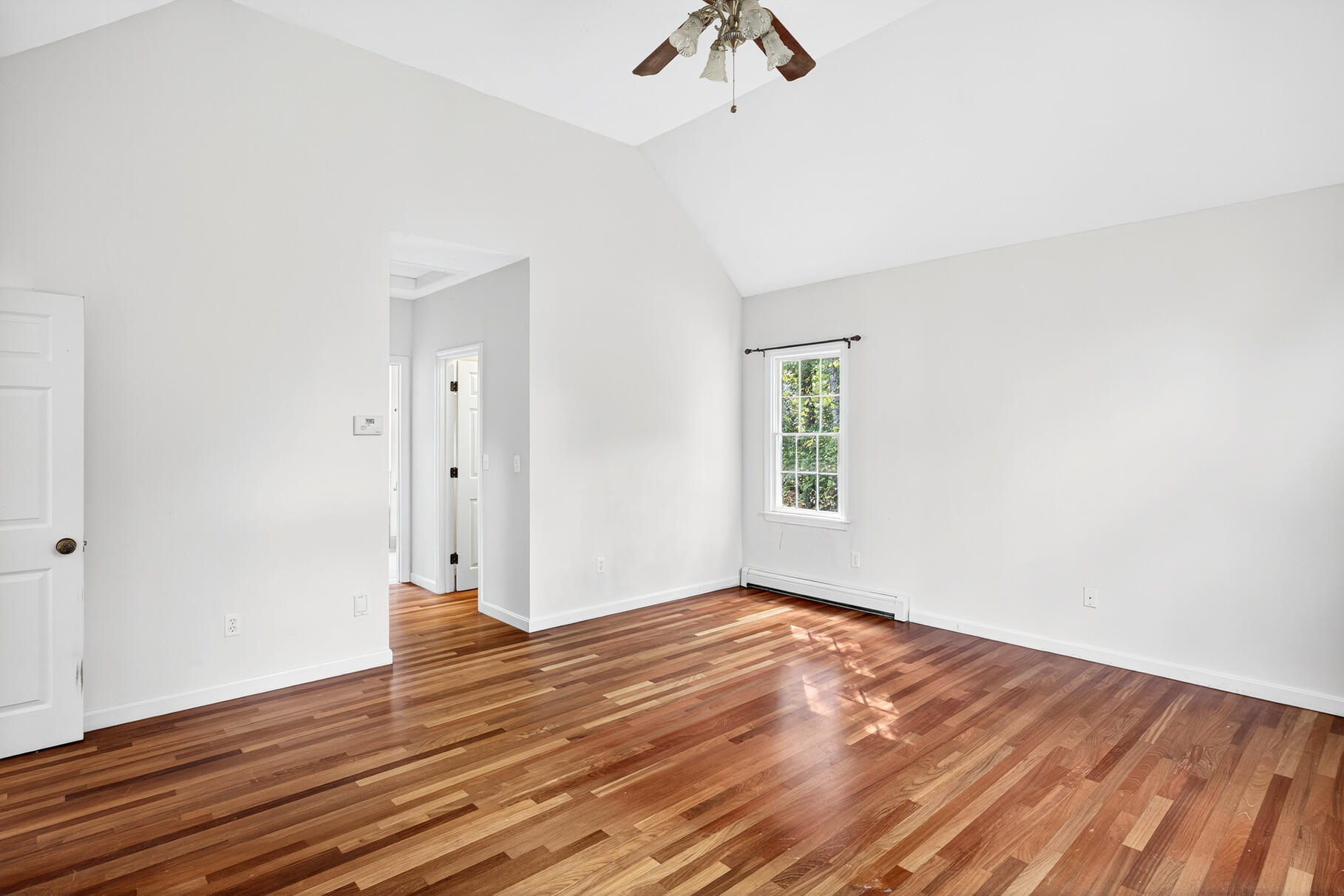 30 Fox Crossing Road Brewster, MA 02631 - Photo 17 of 36 an empty room with wooden floor chandelier fan and windows