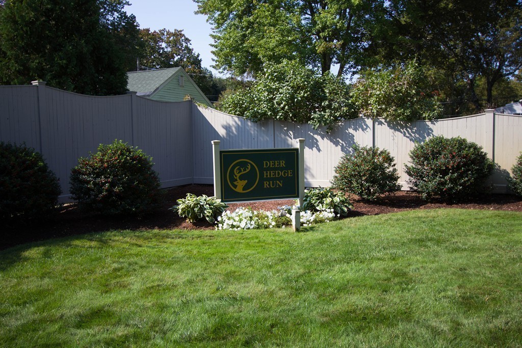13 Deer Path, Unit 3 Maynard, MA 01754 - Photo 20 of 21 a sign that is sitting in the grass with wooden fence