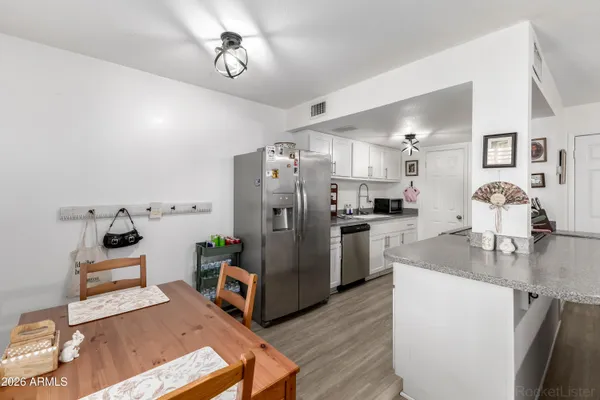 a kitchen with stainless steel appliances kitchen island granite countertop a refrigerator and a stove top oven