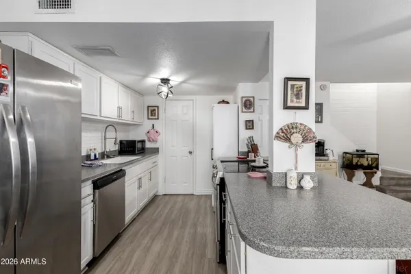 a kitchen with stainless steel appliances granite countertop a sink dishwasher stove and refrigerator