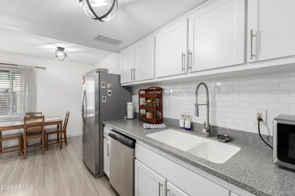 a kitchen with stainless steel appliances granite countertop a sink refrigerator and microwave