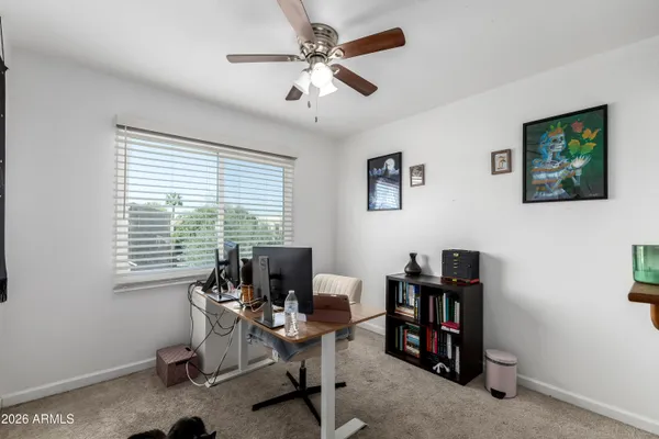 a view of a workspace with furniture and a window