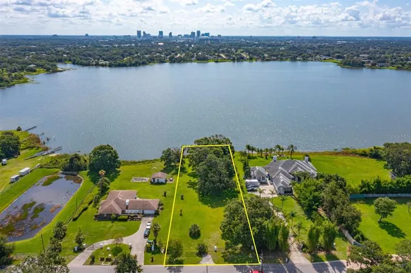 an aerial view of lake residential house with outdoor space and trees around