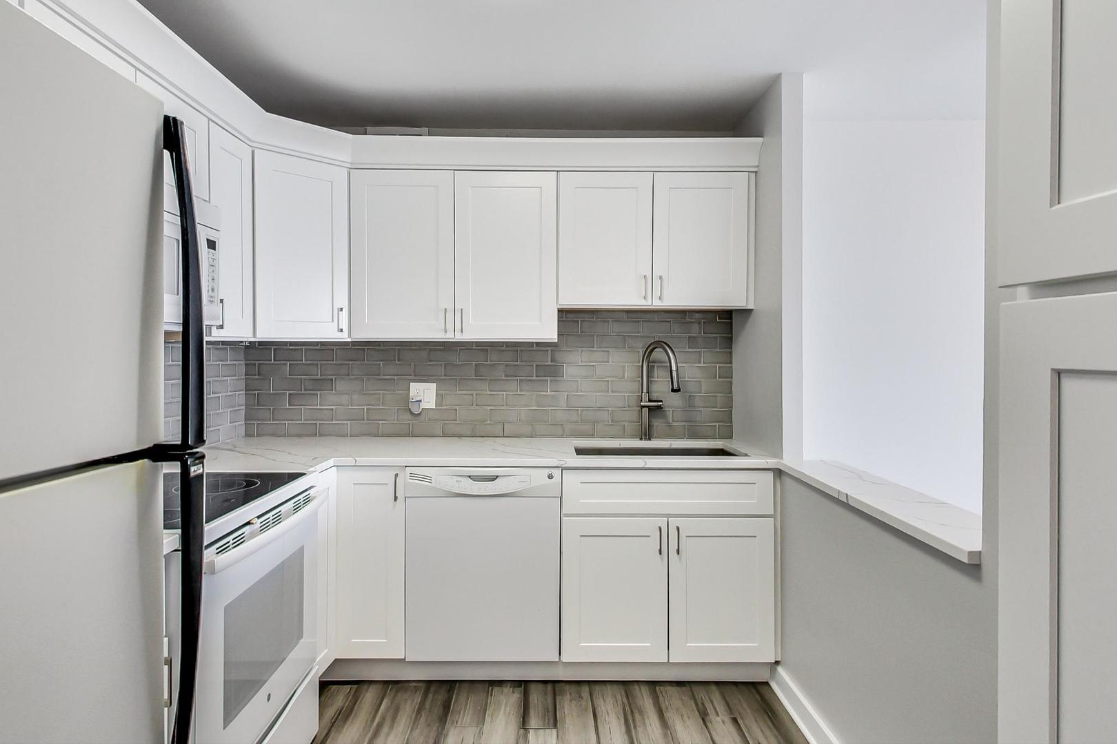 5415 North Sheridan Road, Unit 2904 Chicago, IL 60640 - Photo 25 of 49 a kitchen with white cabinets and white appliances