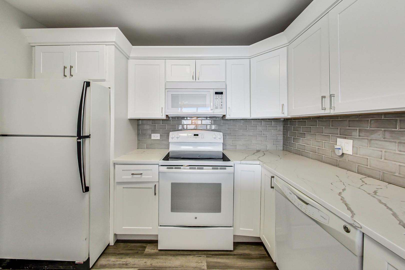 5415 North Sheridan Road, Unit 2904 Chicago, IL 60640 - Photo 26 of 49 a kitchen with a stove top oven and white cabinets