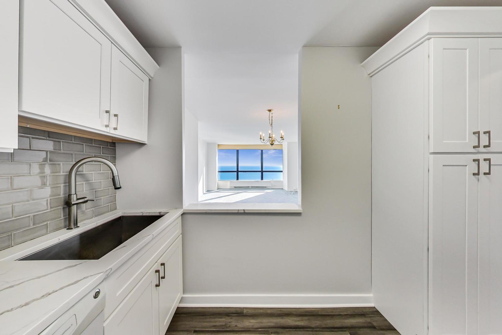 5415 North Sheridan Road, Unit 2904 Chicago, IL 60640 - Photo 27 of 49 a kitchen with white cabinets and sink