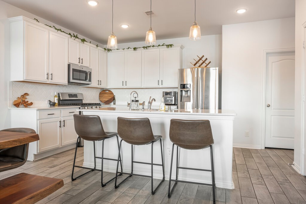 105 Montecito Lane Manvel, TX 77578 - Photo 27 of 39 a kitchen with granite countertop a counter space chairs cabinets and appliances