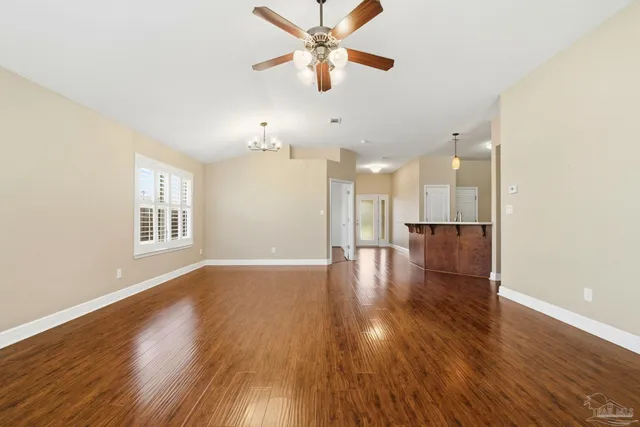 a view of a room with a kitchen wooden floor and a ceiling fan