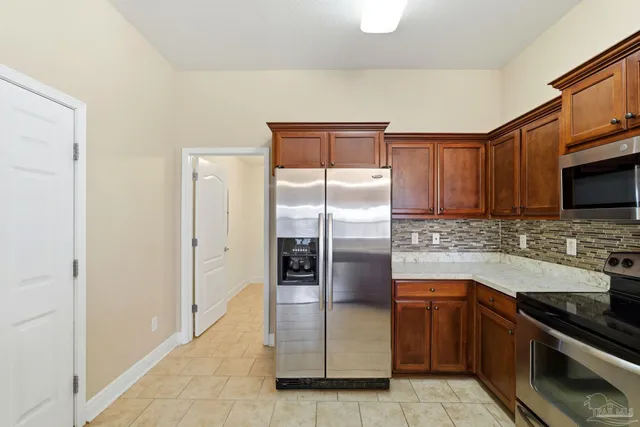 a kitchen with stainless steel appliances granite countertop a refrigerator and a stove