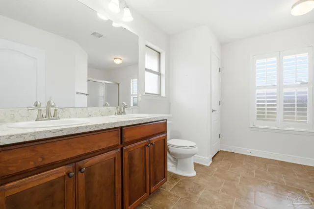 a bathroom with a granite countertop sink a toilet and a mirror