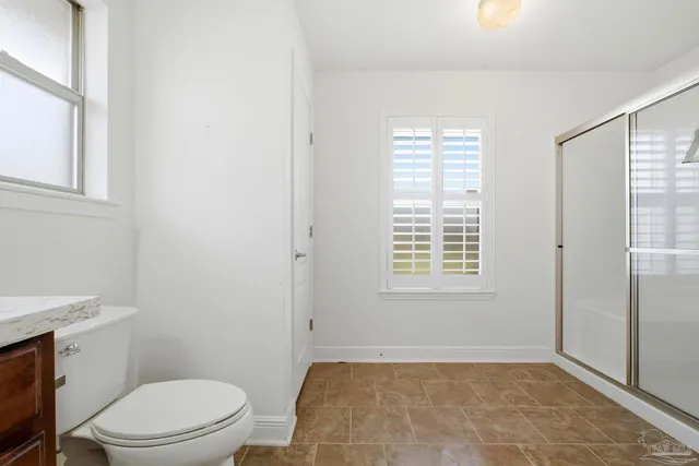 a bathroom with a toilet a sink and a window