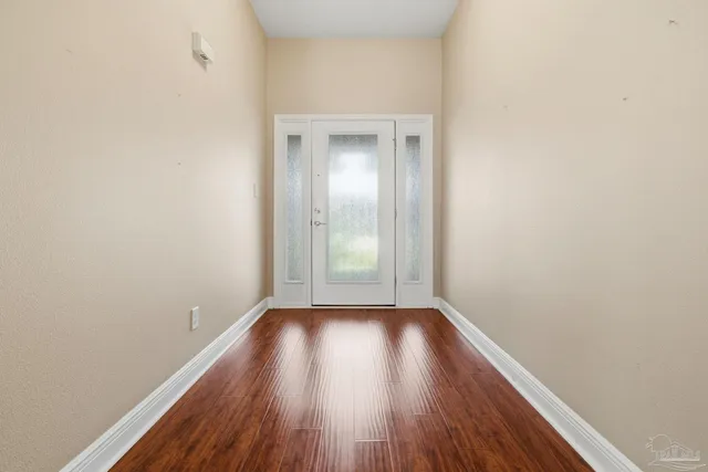 a view of a small space with wooden floor and a window