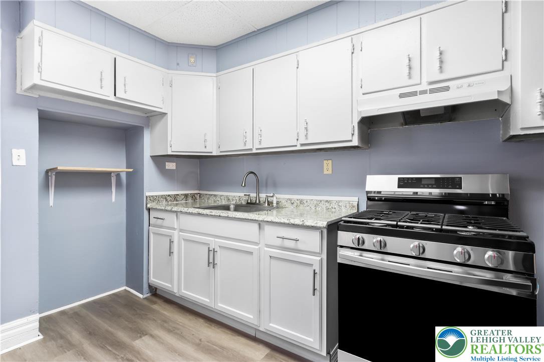 424 Cedar Street Allentown, PA 18102 - Photo 9 of 27 a kitchen with granite countertop white cabinets and stainless steel appliances