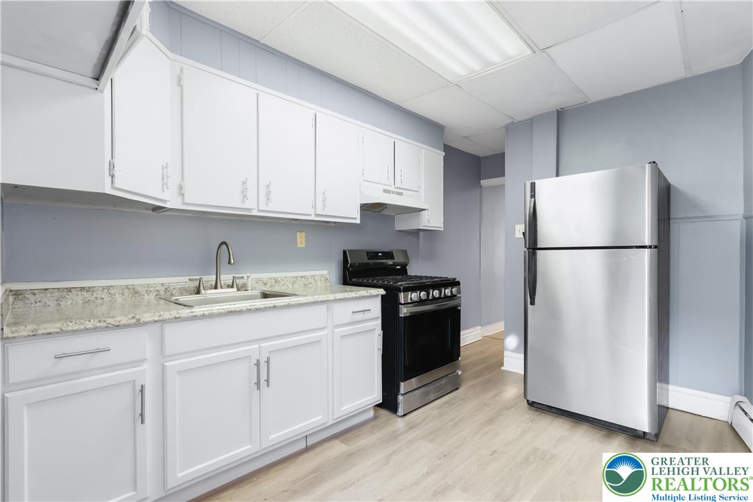 424 Cedar Street Allentown, PA 18102 - Photo 10 of 27 a kitchen with stainless steel appliances granite countertop a refrigerator sink and cabinets