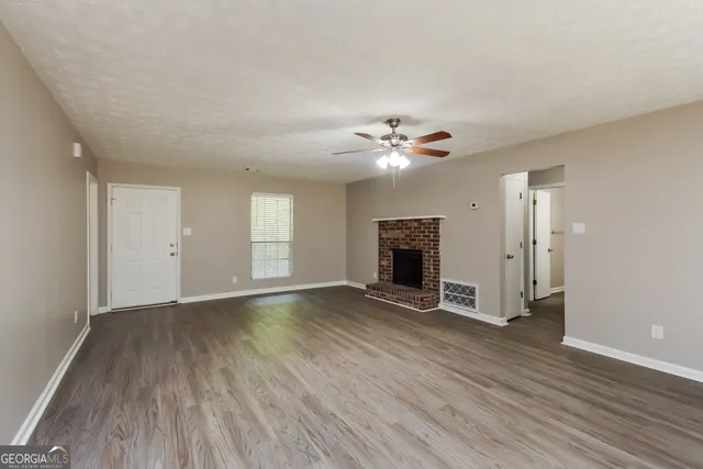 an empty room with wooden floor and fireplace