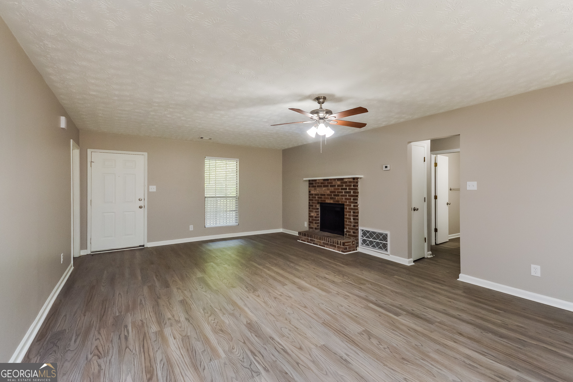 4585 Old Lake Drive Decatur, GA 30034 - Photo 4 of 16 an empty room with wooden floor and fireplace