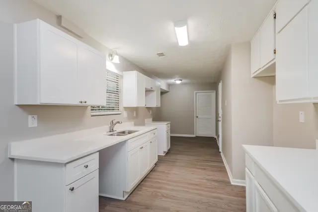 a kitchen with a sink a stove and cabinets