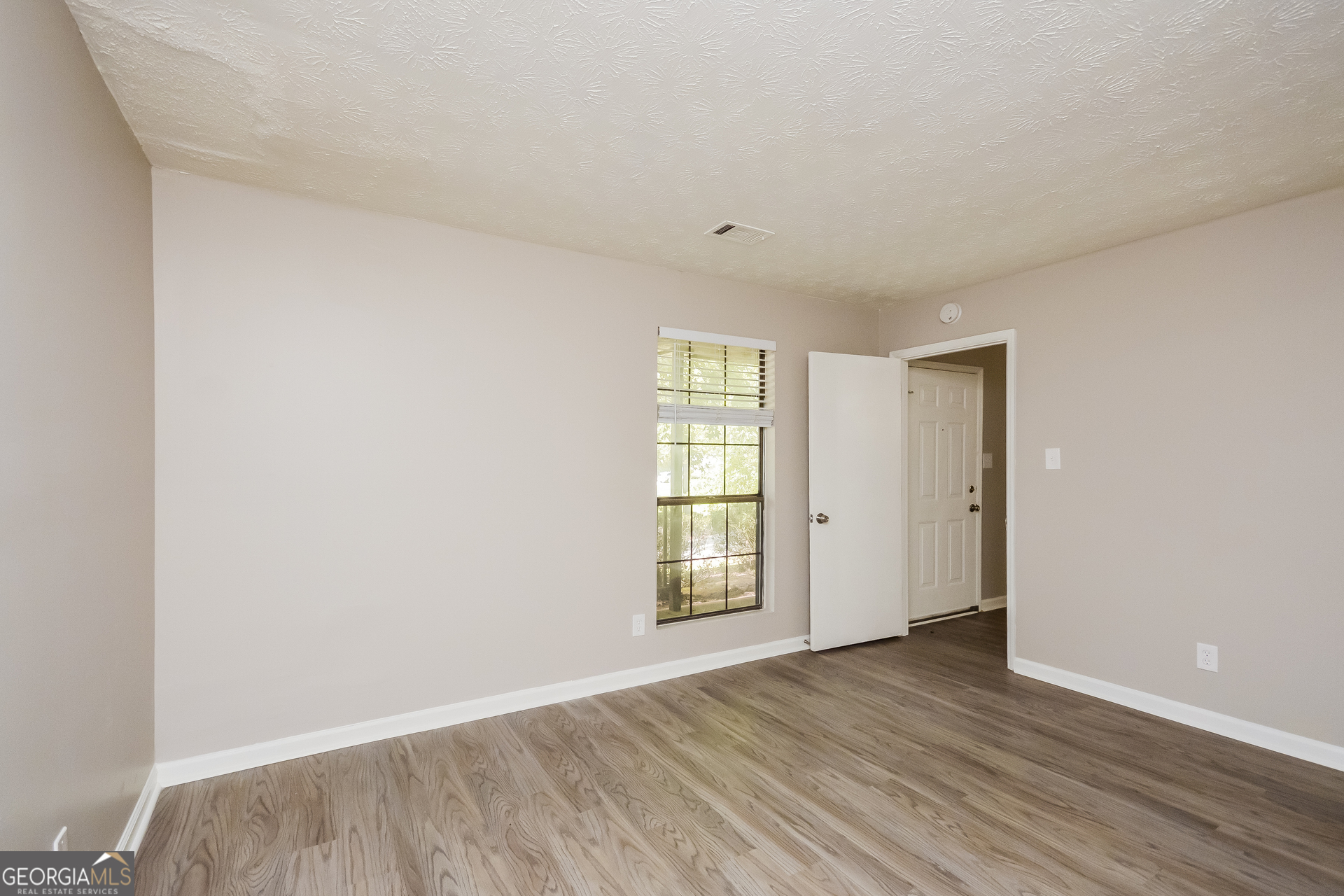 4585 Old Lake Drive Decatur, GA 30034 - Photo 9 of 16 a view of an empty room with wooden floor and a window