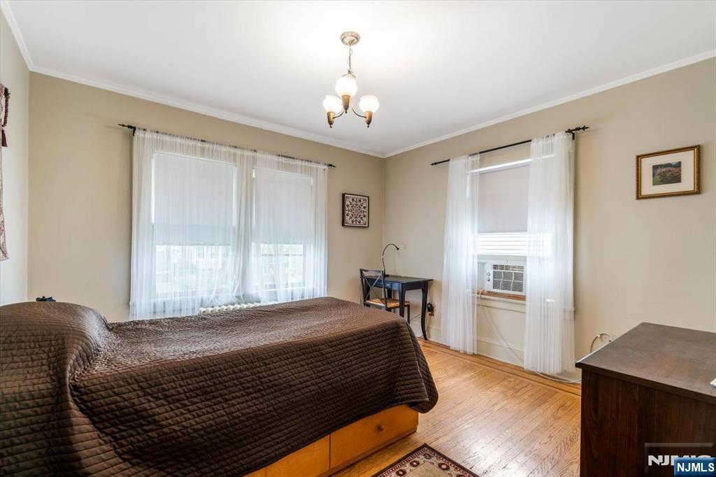 217 Mountain Way Rutherford, NJ 07070 - Photo 16 of 28 a bedroom with a large bed and a chandelier
