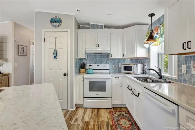 an aerial view of a city with lots of residential buildings and ocean view in back