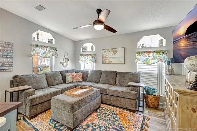 a kitchen with stainless steel appliances a refrigerator a sink a stove a dining table and chairs with wooden floor