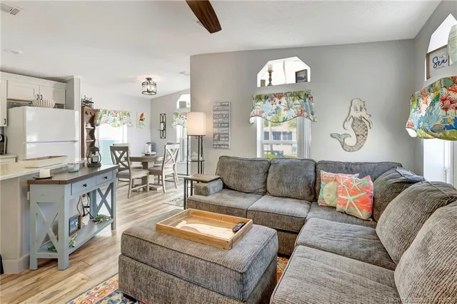 a kitchen with stainless steel appliances granite countertop a dining table chairs refrigerator and sink