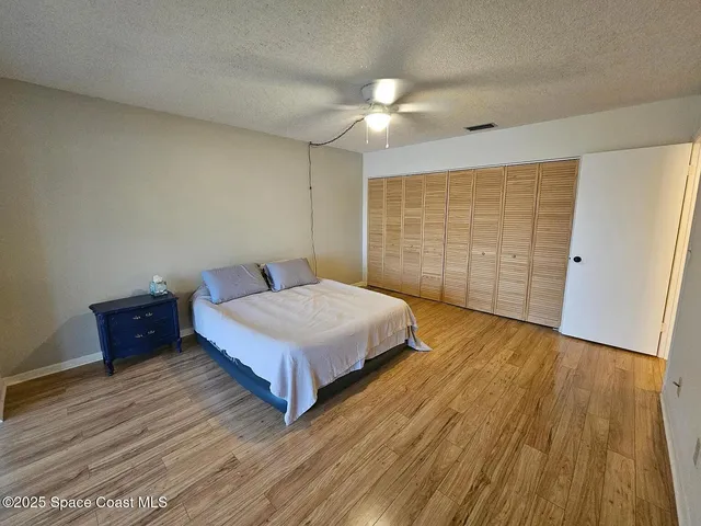 a bedroom with a bed and wooden floor