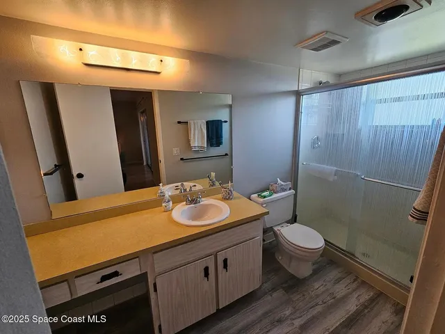 a bathroom with a granite countertop sink toilet and shower