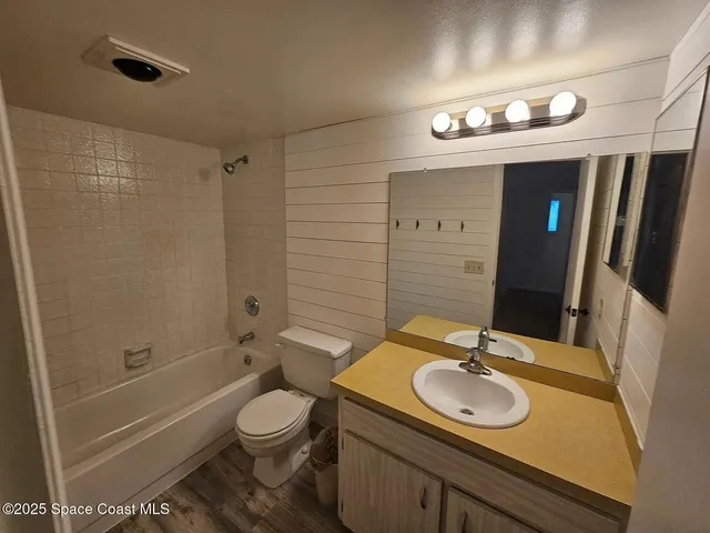 a bathroom with a sink a toilet and shower a mirror