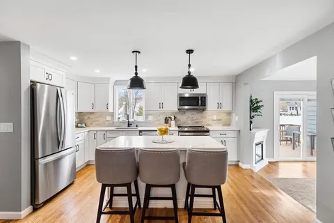 a kitchen with cabinets appliances a sink and a window