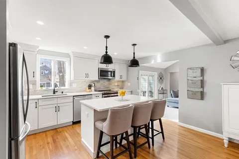 a kitchen that has a sink and a stove with white countertops