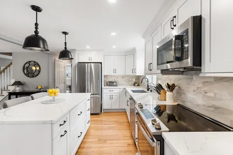 a kitchen with stainless steel appliances a stove a sink island and a refrigerator