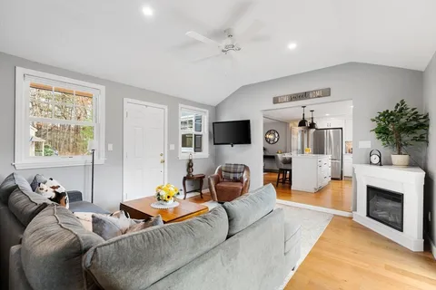 a living room with furniture a flat screen tv and a fireplace