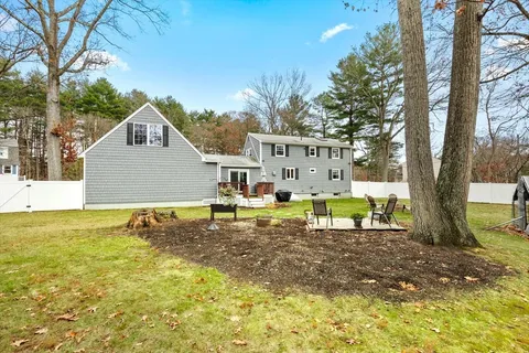 a view of a house with backyard and sitting area