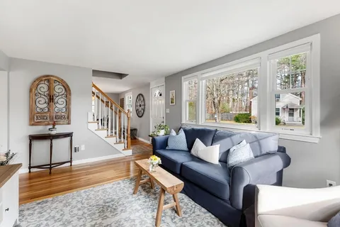 a living room with furniture and a large window with wooden floor