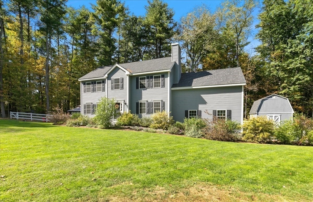 a front view of a house with a yard and trees