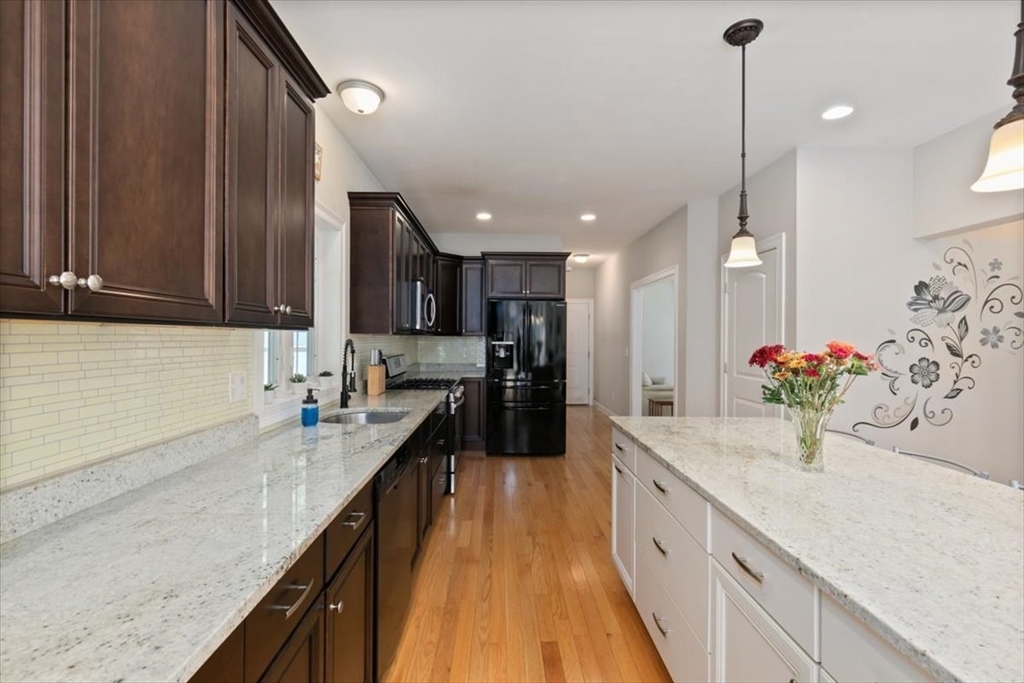 135 Pepperell Road Groton, MA 01450 - Photo 4 of 41 a large kitchen with kitchen island granite countertop a sink and cabinets