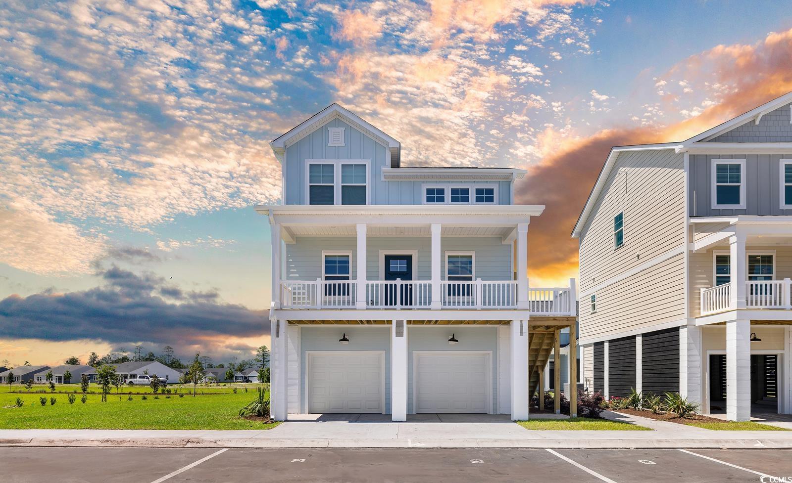 Raised beach house with board and batten siding and a garage