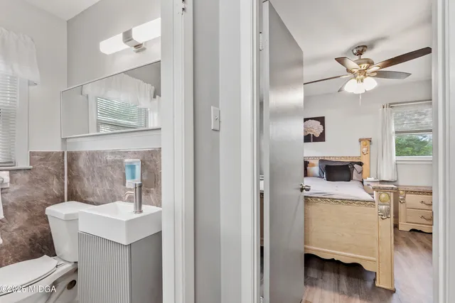 a bathroom with a sink a toilet and a mirror