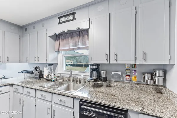 a kitchen with stainless steel appliances granite countertop a sink a stove and cabinets