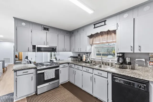 a kitchen with stainless steel appliances a sink stove and cabinets