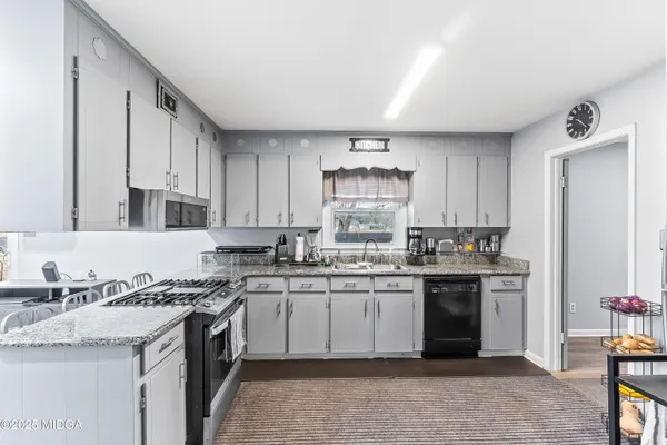 a kitchen with a sink stove top oven and cabinets