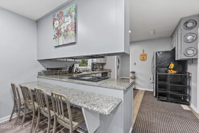 a kitchen with granite countertop a stove and cabinets